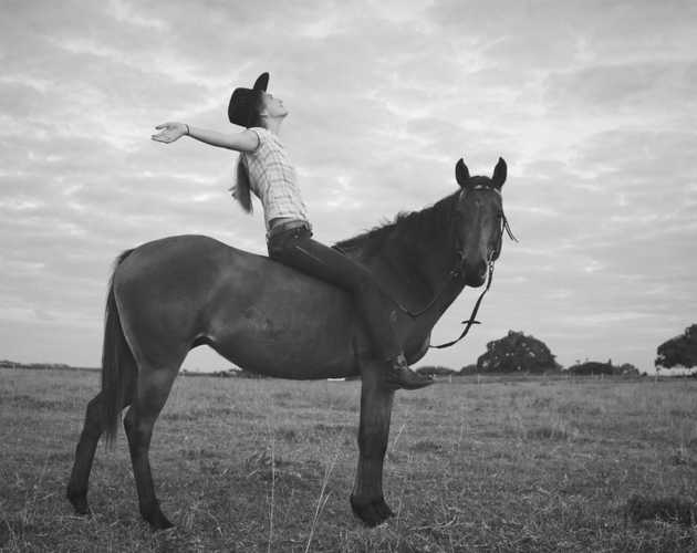 grayscale photography of woman riding horse on grass field